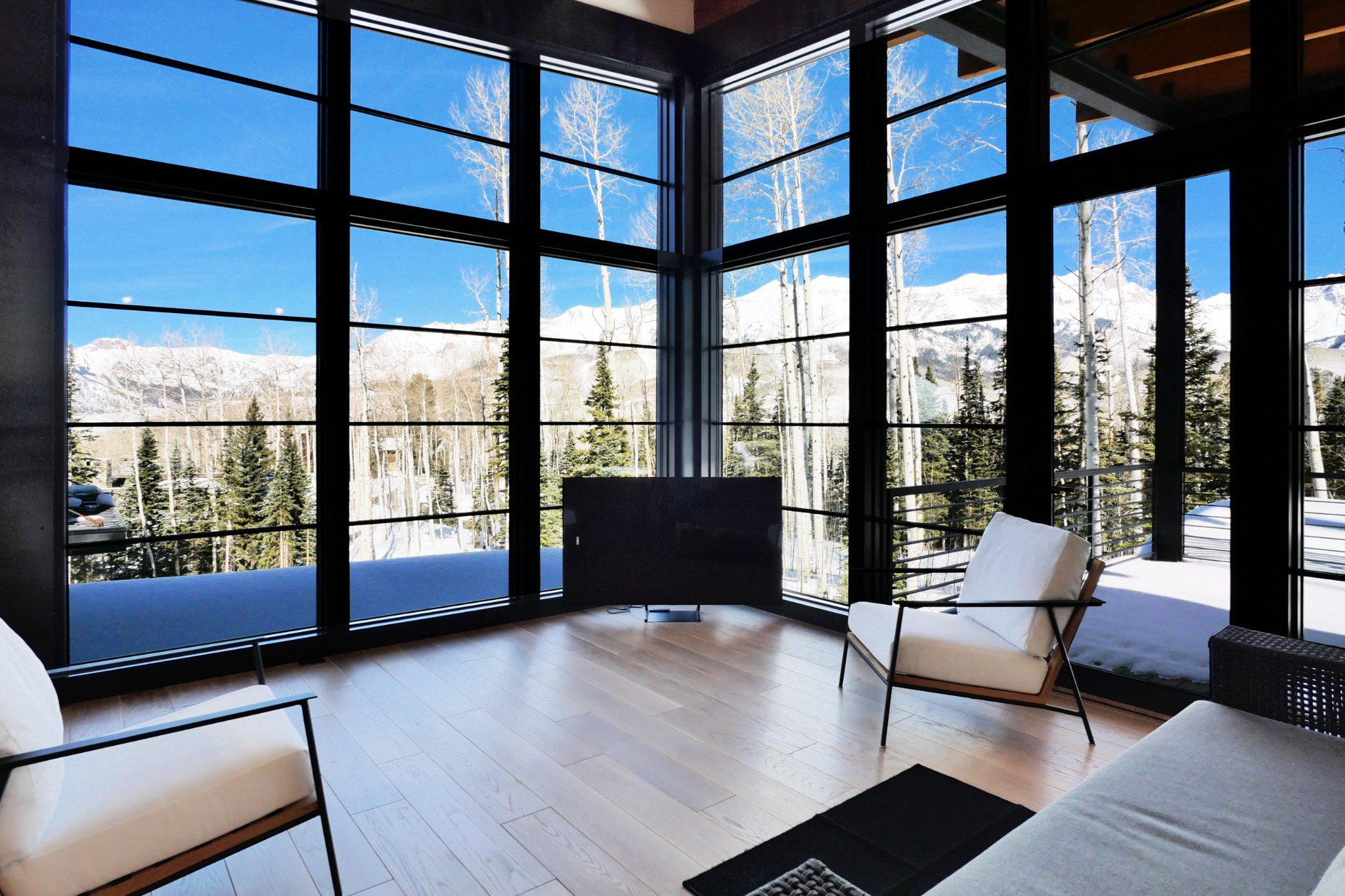 Living area — floor-to-ceiling windows, mountain panorama